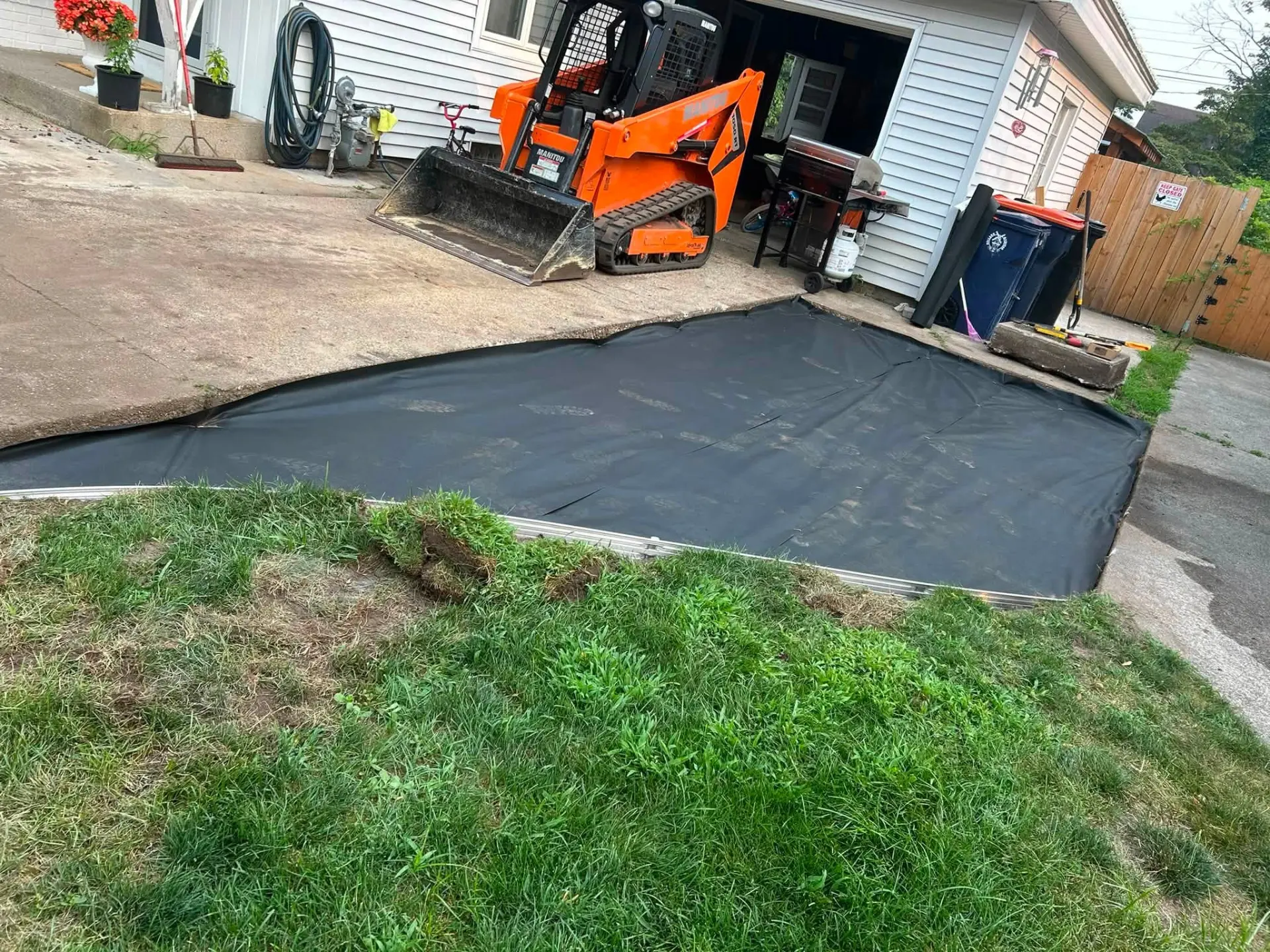 Excavated patio base with weed barrier ready for stone in Holland, MI